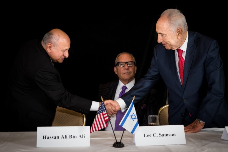 Hassan Ali Bin Ali shaking hands with Israeli President Shimon Peres